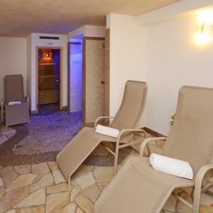 um quarto com cadeiras e um corredor com uma porta em La Campagnola em Canazei
