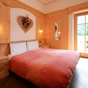 una camera da letto con un letto con un cuore sul muro di La Campagnola a Canazei