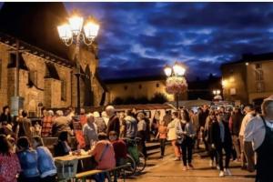 Eine Menschenmenge, die nachts eine Straße entlangläuft. in der Unterkunft Town Centre with garden & free parking Le Dorat in Le Dorat