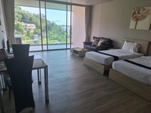 ein Hotelzimmer mit 2 Betten, einem Tisch und einem Sofa in der Unterkunft Veloche Karon in Karon Beach