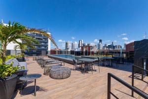 a rooftop patio with tables and chairs on a building at Way Tambaú #E6 - Quádruplo deluxe por Carpediem in Tambaú