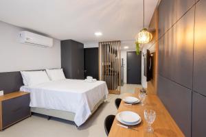 a bedroom with a bed and a table and chairs at Way Tambaú #E6 - Quádruplo deluxe por Carpediem in Tambaú +38 photos