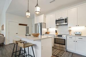 a kitchen with white cabinets and a island with bar stools at Evergreen On Main in Blowing Rock