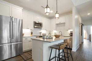 a kitchen with white cabinets and a stainless steel refrigerator at Evergreen On Main in Blowing Rock