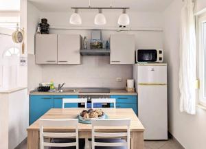 a kitchen with a table and chairs and a refrigerator at Apartment Sea Garden in Ičići
