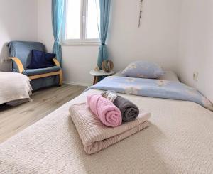 a bedroom with two beds with towels on them at Apartment Sea Garden in Ičići
