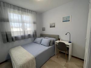 Un dormitorio pequeño con una cama y un escritorio. en Small room in 4 bedroom penthouse Spectacular patio views, en Puerto de Santiago