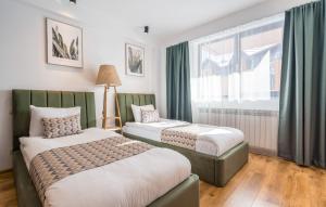 two beds in a room with a window at New Gudauri Geoflats in Gudauri