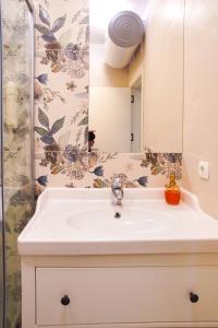 a bathroom with a white sink and a mirror at Didi's Central Designer Apartments in Sofia