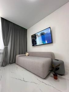 a bedroom with a couch and a tv on the wall at Бизнес-класса in Kostanay