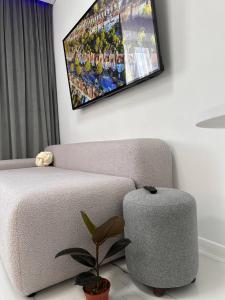 a living room with a couch and a tv on the wall at Бизнес-класса in Kostanay