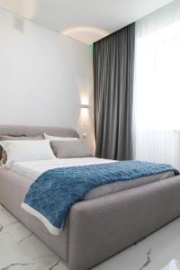 a bedroom with a bed with a blue blanket on it at Бизнес-класса in Kostanay
