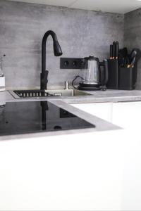 a kitchen with a sink with a tea kettle on it at Бизнес-класса in Kostanay