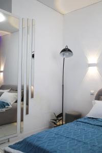 a bedroom with a blue bed and a mirror at Бизнес-класса in Kostanay