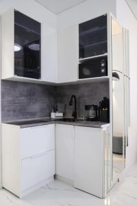 a kitchen with white cabinets and a sink at Бизнес-класса in Kostanay