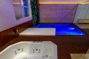 a bath tub in a bathroom with a blue pool at Apple Motel ( Adults Only ) in São Paulo +16 photos