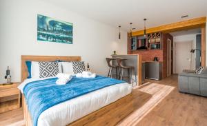 a bedroom with a large bed with a blue blanket at New Gudauri Geoflats in Gudauri