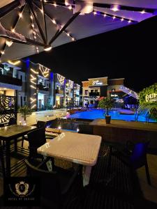 ベニンシティにある2 Bed Apartment 6 - Chic Benin City Hideawayの- パティオ(テーブル付)、夜間のプール