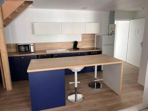 a kitchen with a counter with a blue island in it at Chez TH'Auxonne in Auxonne