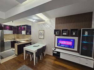 a kitchen and dining room with a table and a tv at AS Apartment in Podgorica