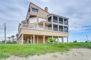 a large house on the beach with a green field at Oceanfront Galveston Beach House Steps to Sand! in Galveston