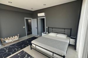 a bedroom with a bed and a gray wall at Villa RADA in Bogazici +17 photos