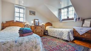 a bedroom with two beds and two windows at The Coach House in Wareham