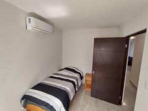a white room with a bed and a closet at Departamento completo para ejecutivo o pareja in Tampico +6 photos
