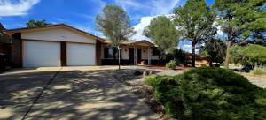 a house with a garage and a driveway at Hot Air Balloon Haven, King Bed, Office, Foosball, Crib in Albuquerque