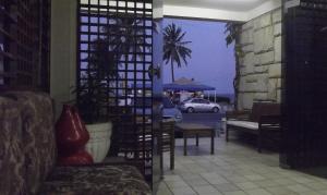 a patio with a table and a car on a street at Escuna Praia Hotel in João Pessoa