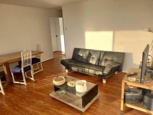 a living room with a leather couch and a table at Reñaca Gran terraza con vista al mar in Viña del Mar +29 photos