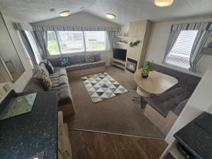 a living room with a couch and a table at Lyon’s Robin Hood Rhyl caravan sbw in Rhyl