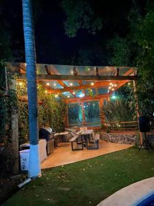 ein Hinterhof mit einer Pergola mit Tisch und Grill in der Unterkunft Casa de los ángeles en el centro in Malinalco