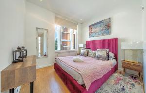 a bedroom with a large bed with a pink headboard at DESIGNER Victorian Flat with HUGE Terrace in London