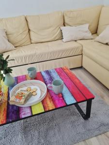 a coffee table with a plate of food on top of a couch at Apartmán Horný Smokovec in Smokovce