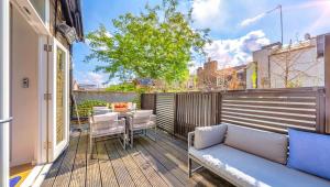 a patio with a couch and a table on a balcony at DESIGNER Victorian Flat with HUGE Terrace in London