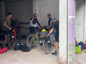 a group of men standing around their bikes in a garage at Hotel Reci in Peshkopi +15 photos