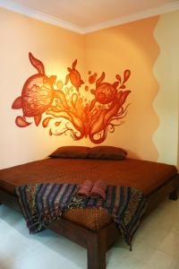 a bedroom with a bed with a painting on the wall at Hotel 1001 Malam in Yogyakarta