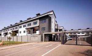 an empty parking lot in front of a building at Mya Villa 2 in Fourways
