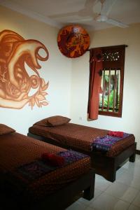 a room with two beds and a window with a dragon on the wall at Hotel 1001 Malam in Yogyakarta
