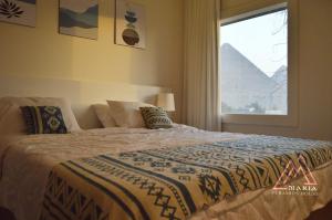 una camera da letto con un letto grande con una finestra di Maria Pyramids House a Il Cairo
