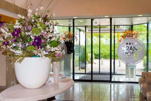 een grote witte vaas gevuld met bloemen op een tafel bij Grand Hotel Amstelveen in Amstelveen
