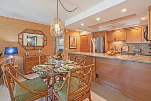 a kitchen with a table and chairs and a bar at Kahana Sunset B4B in Kahana