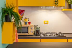 a kitchen with a stove and a microwave at CASA ALLEGRA appartamento in centro Palmanova in Palmanova