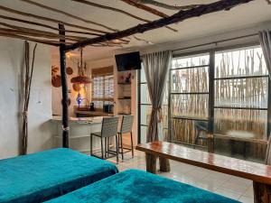 a bedroom with two beds and a table and a kitchen at Departamentos Maya in Isla Mujeres