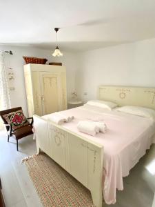 a bedroom with a large white bed and a chair at Casa rio Lera in Amandola