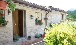a brick house with a door and some plants at Casa rio Lera in Amandola