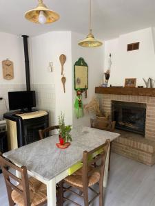 a dining room with a table and a fireplace at Casa rio Lera in Amandola