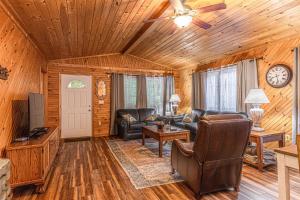 ein Wohnzimmer mit Ledermöbeln und einem Deckenventilator in der Unterkunft Diamond Creek Cabin in Bryson City