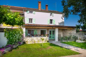 an exterior view of a white house with a yard at House Ladonja with private pool in Bale